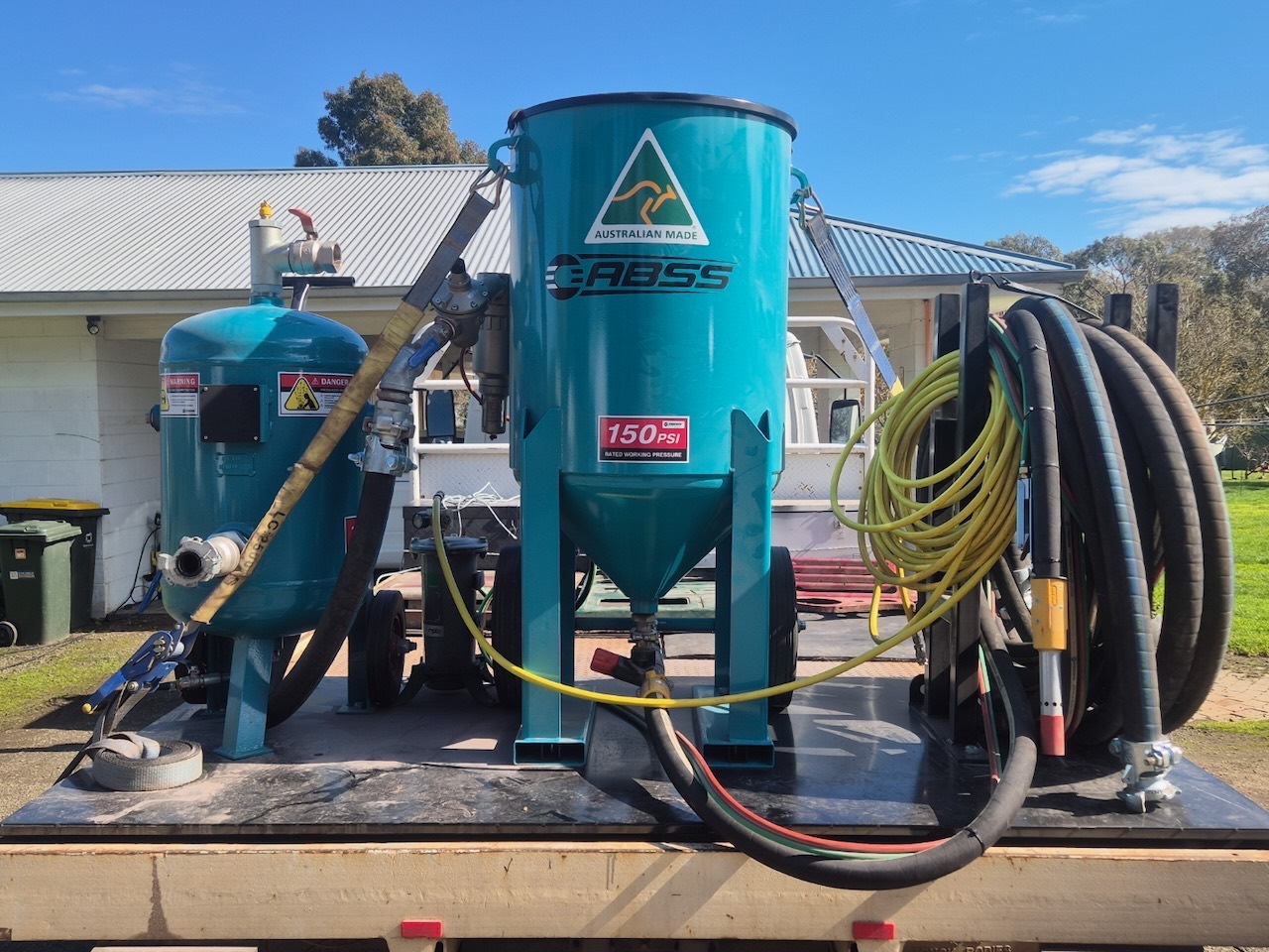 Truck-mounted mobile blasting rig — twin blast pots and hoses on the deck